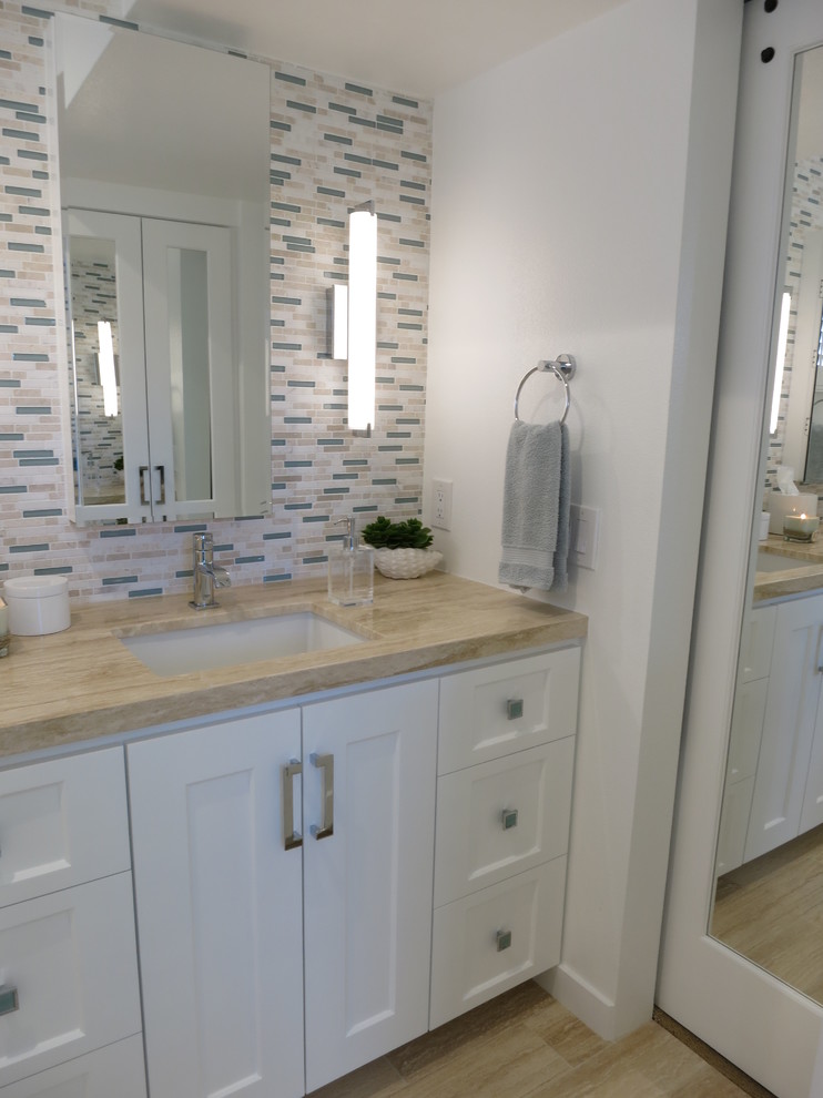 Small beach style master white tile and mosaic tile travertine floor bathroom photo in Los Angeles with an undermount sink, shaker cabinets, white cabinets, marble countertops and white walls