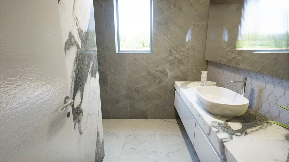 ニューヨークにあるおしゃれな浴室 (大理石タイル、大理石の洗面台) の写真