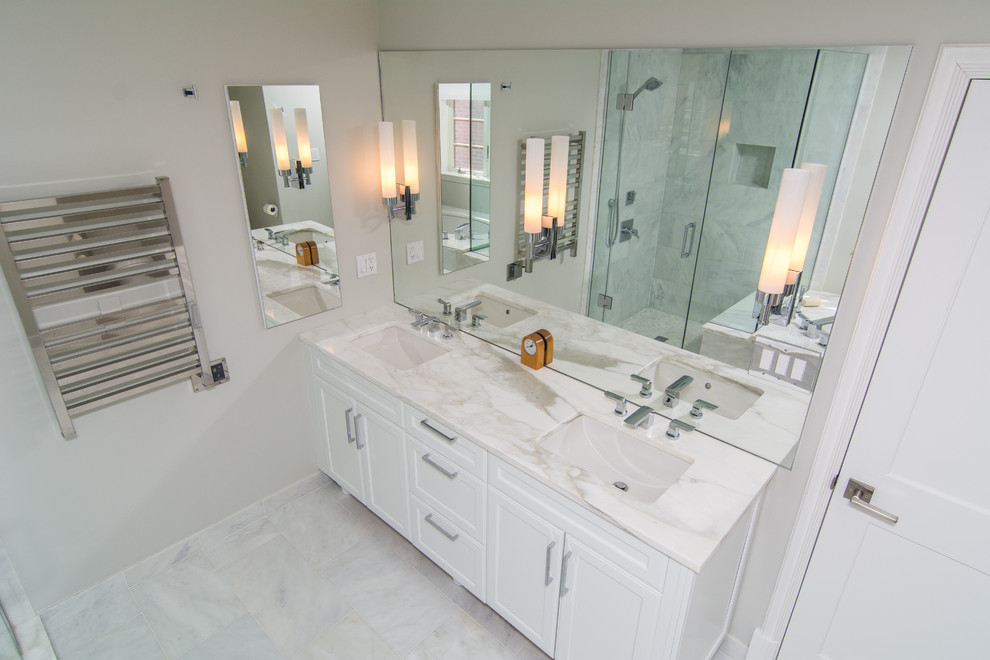 Modern inredning av ett mellanstort en-suite badrum, med ett undermonterad handfat, vita skåp, marmorbänkskiva, ett undermonterat badkar, en dusch i en alkov, vit kakel, stenkakel, beige väggar och marmorgolv