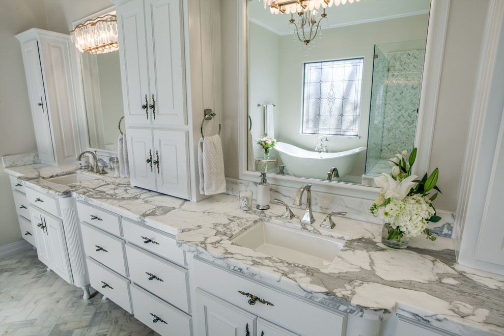 Пример оригинального дизайна: главная ванная комната среднего размера в стиле неоклассика (современная классика) с фасадами с утопленной филенкой, белыми фасадами, ванной на ножках, угловым душем, унитазом-моноблоком, белой плиткой, стеклянной плиткой, розовыми стенами, мраморным полом, врезной раковиной и мраморной столешницей