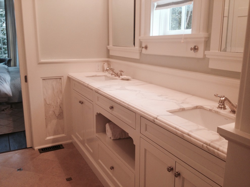 Esempio di una stanza da bagno padronale chic con pareti bianche, lavabo sottopiano, top in marmo, pavimento beige e ante bianche