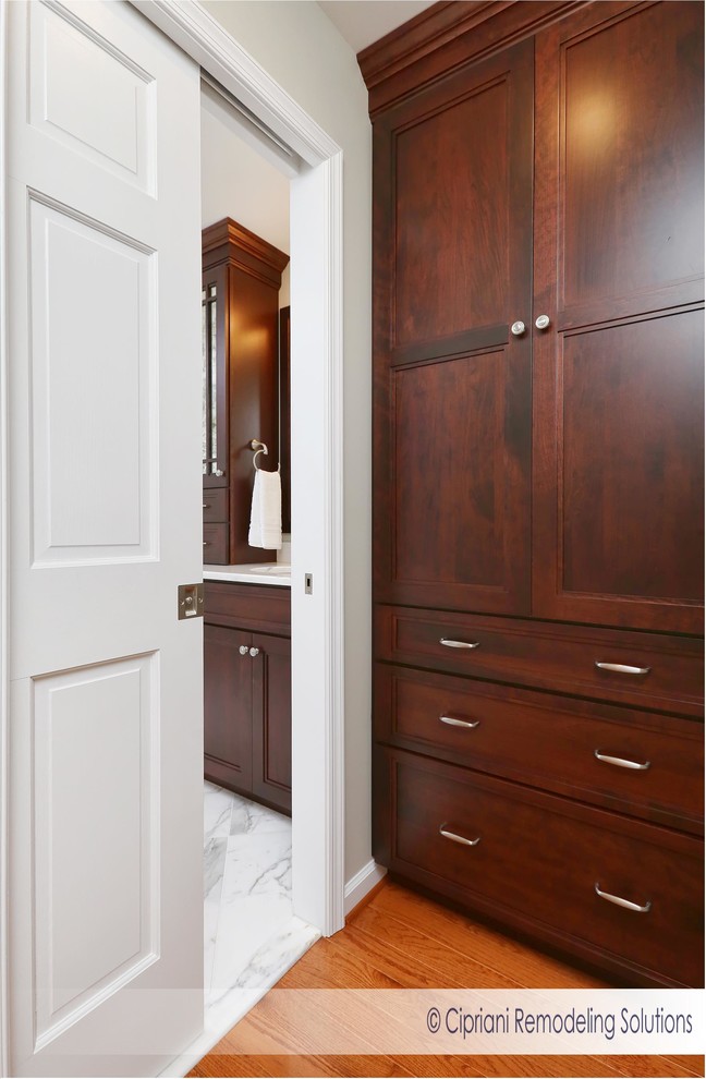 Design ideas for a medium sized traditional ensuite bathroom in Philadelphia with flat-panel cabinets, dark wood cabinets, a freestanding bath, a corner shower, a two-piece toilet, white tiles, marble tiles, beige walls, marble flooring, a submerged sink and marble worktops.