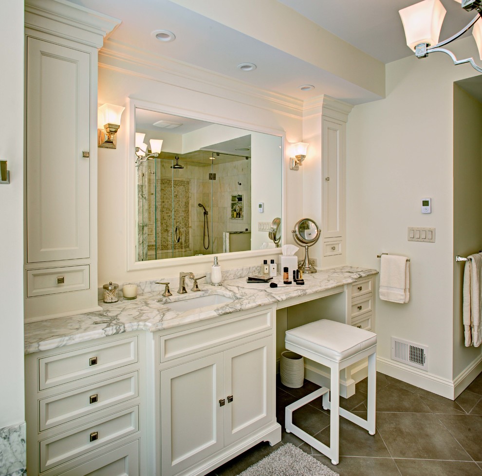 Bild på ett mellanstort vintage en-suite badrum, med luckor med profilerade fronter, vita skåp, en dusch i en alkov, beige kakel, vit kakel, marmorkakel, vita väggar, klinkergolv i porslin, ett undermonterad handfat, marmorbänkskiva, beiget golv och dusch med gångjärnsdörr