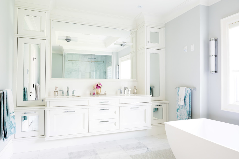 Пример оригинального дизайна: ванная комната в стиле неоклассика (современная классика) с врезной раковиной, фасадами с утопленной филенкой, белыми фасадами, отдельно стоящей ванной и серыми стенами