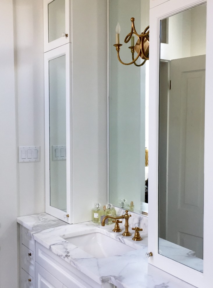 Klassisk inredning av ett stort en-suite badrum, med luckor med infälld panel, ett undermonterat badkar, en dusch/badkar-kombination, vit kakel, marmorkakel, vita väggar, marmorgolv, ett undermonterad handfat, marmorbänkskiva, vitt golv och dusch med gångjärnsdörr