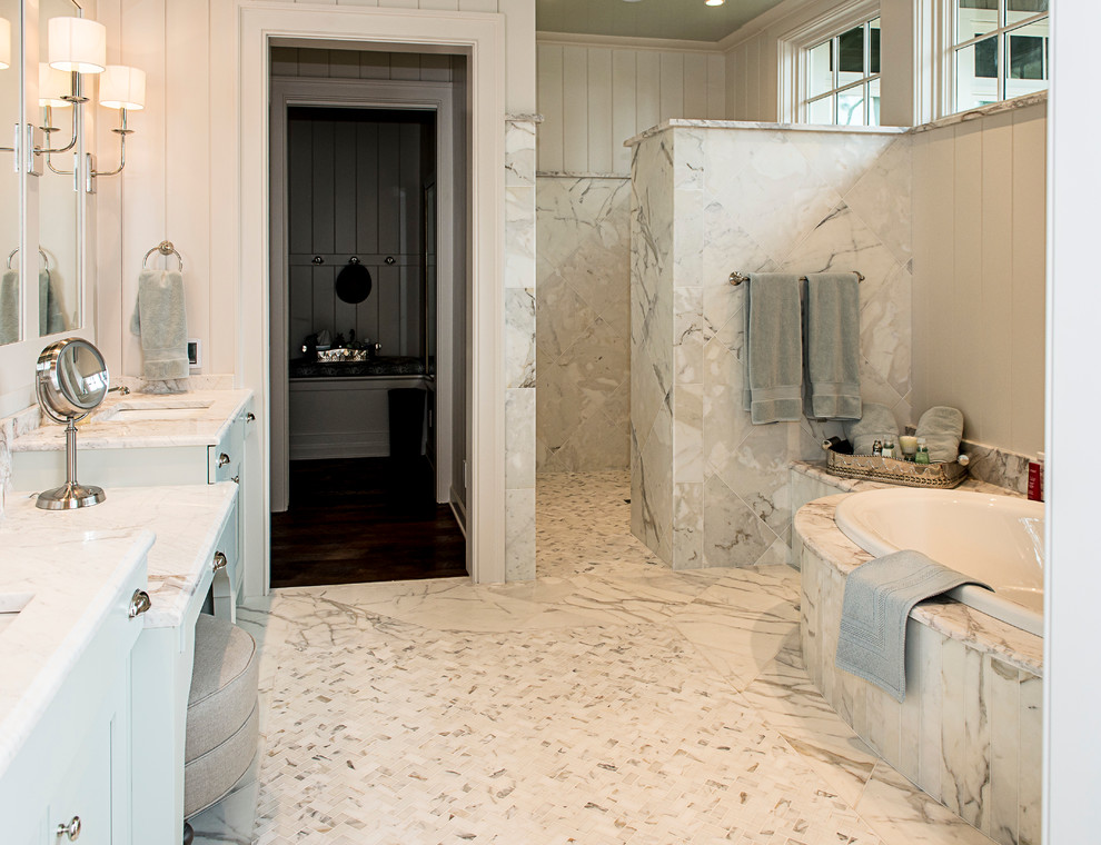 Foto på ett stort funkis en-suite badrum, med skåp i shakerstil, vita skåp, ett platsbyggt badkar, en kantlös dusch, beige kakel, beige väggar, marmorgolv, ett undermonterad handfat, marmorbänkskiva och stenkakel