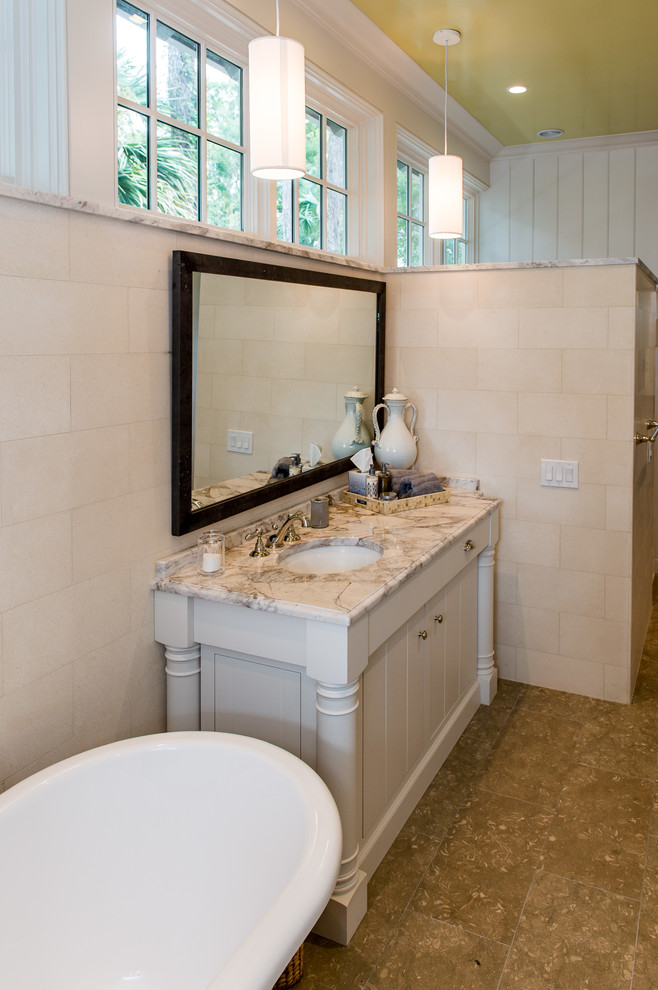 Idéer för stora funkis en-suite badrum, med möbel-liknande, skåp i ljust trä, en kantlös dusch, vit kakel, beige väggar, kalkstensgolv, ett undermonterad handfat, marmorbänkskiva, ett badkar med tassar och porslinskakel