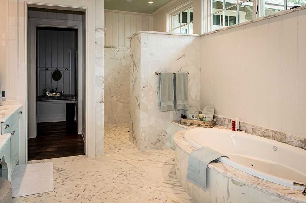 Inspiration pour une grande salle de bain principale design avec un placard à porte shaker, des portes de placard blanches, une baignoire posée, une douche à l'italienne, un carrelage beige, un mur beige, un sol en marbre, un plan de toilette en marbre, un lavabo encastré et un carrelage de pierre.