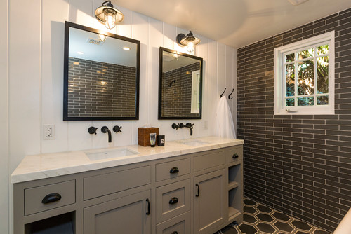 Rustic-style bathroom cabinets with gray double vanity, white marble countertop, and farmhouse lighting fixtures in a cottage bathroom