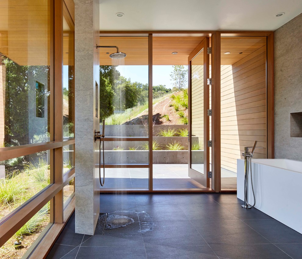 Idéer för 50 tals en-suite badrum, med ett fristående badkar, våtrum, med dusch som är öppen, grå kakel, grå väggar och svart golv