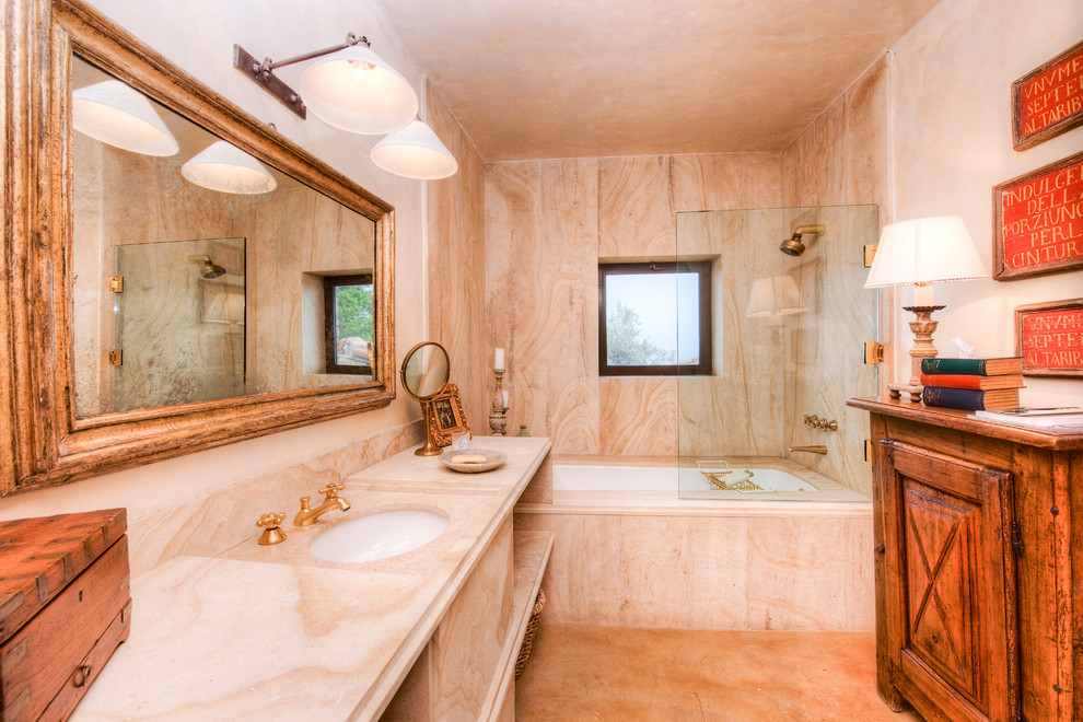 Idée de décoration pour une grande salle de bain principale méditerranéenne en bois clair avec un lavabo encastré, un placard à porte plane, un plan de toilette en quartz, une baignoire posée, un combiné douche/baignoire, un carrelage beige, des dalles de pierre, un mur beige et sol en béton ciré.