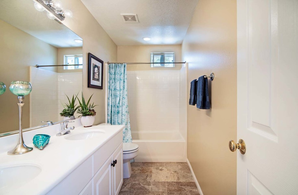 Transitional multicolored tile limestone floor tub/shower combo photo in Orange County with an undermount sink, raised-panel cabinets, white cabinets, a hot tub and beige walls