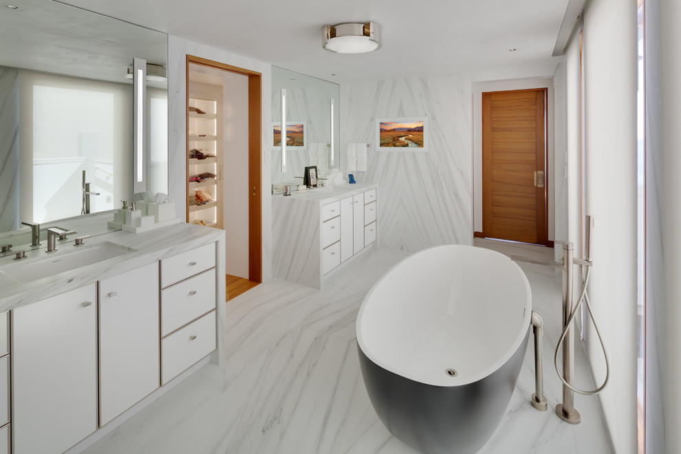 Immagine di una stanza da bagno padronale stile marino di medie dimensioni con ante lisce, ante bianche, vasca freestanding, pareti bianche, pavimento in marmo, lavabo sottopiano, pavimento bianco e top bianco