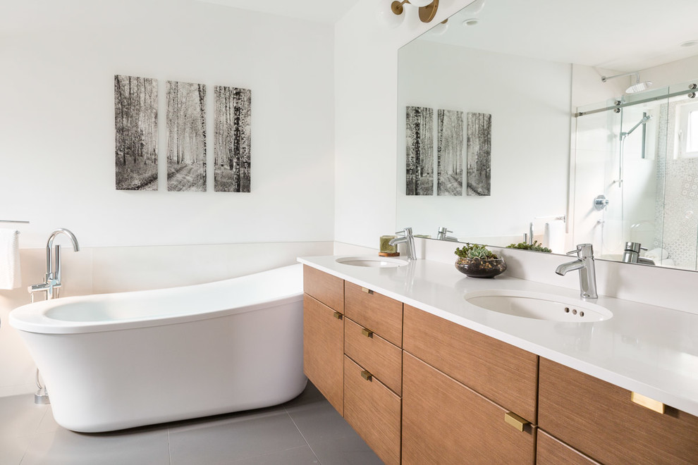 Aménagement d'une grande salle de bain principale contemporaine en bois brun avec un placard à porte plane, une baignoire indépendante, un mur blanc, un lavabo encastré, un plan de toilette en quartz et un sol gris.