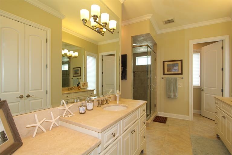 Klassisk inredning av ett mellanstort en-suite badrum, med ett undermonterad handfat, vita skåp, granitbänkskiva, ett japanskt badkar, en dusch/badkar-kombination, en toalettstol med hel cisternkåpa, beige kakel, keramikplattor, gula väggar och klinkergolv i keramik