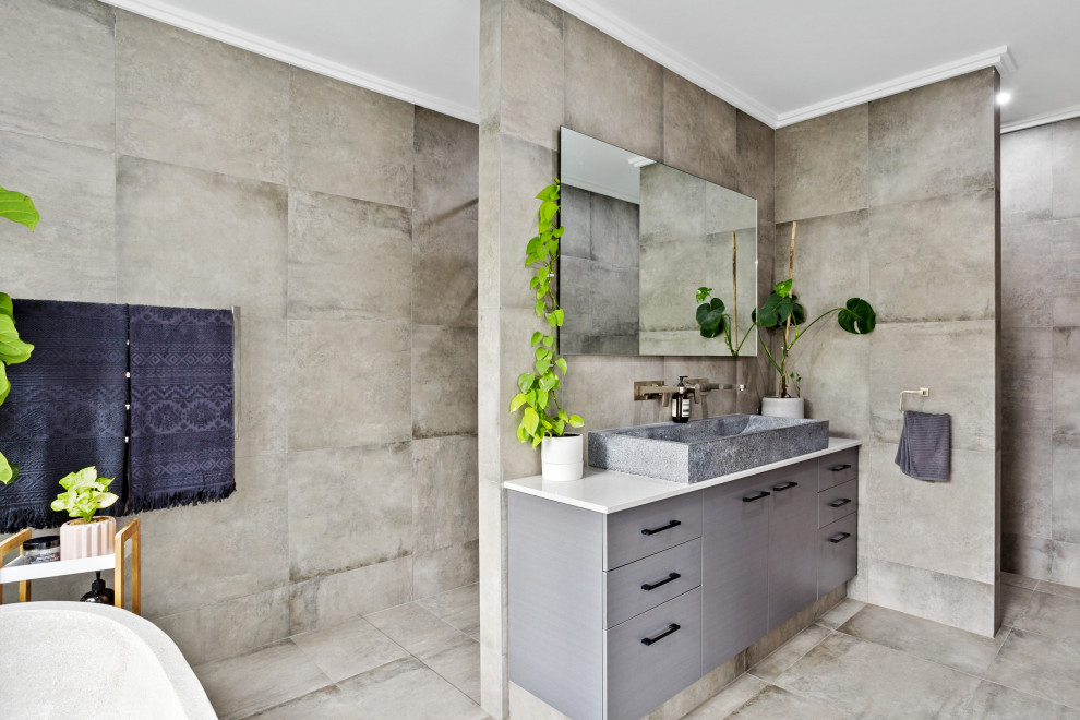 Exempel på ett modernt vit vitt badrum, med släta luckor, grå skåp, ett fristående badkar, en kantlös dusch, grå kakel, ett fristående handfat, grått golv och med dusch som är öppen