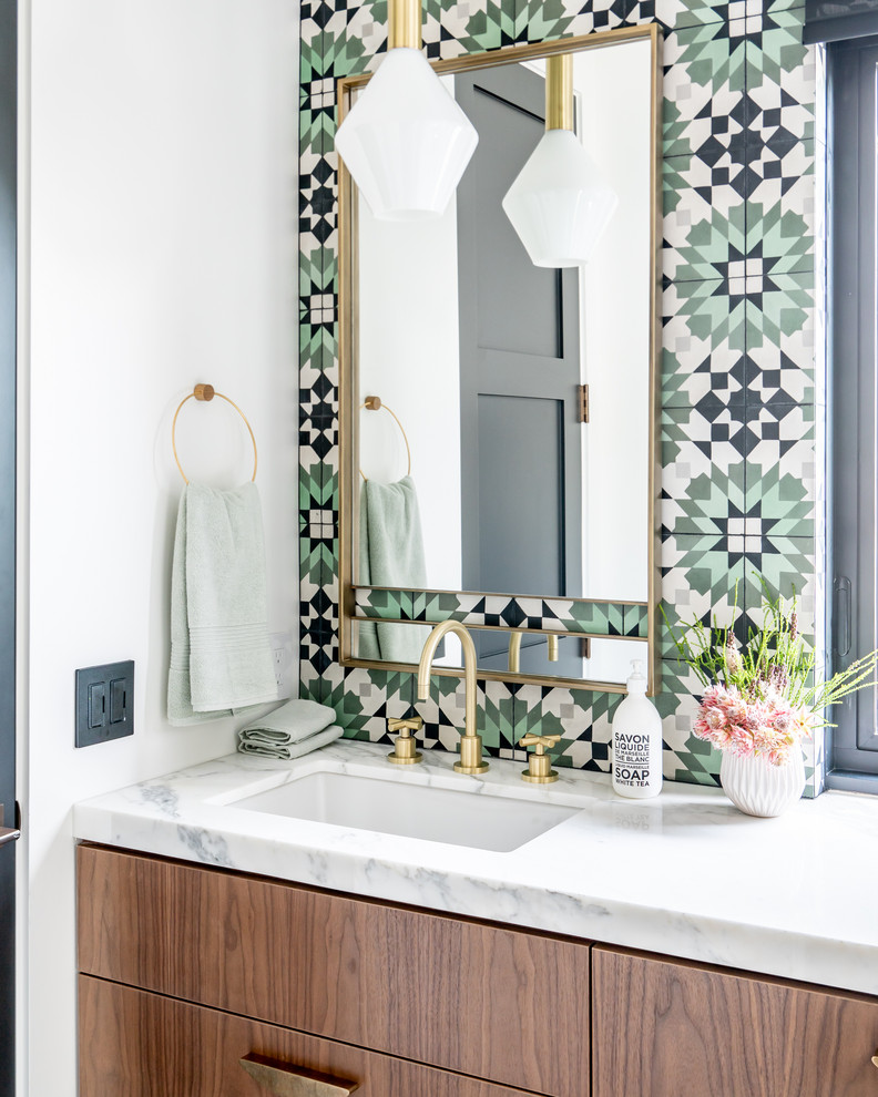 Cette photo montre une salle de bain méditerranéenne en bois brun avec un placard à porte plane, un carrelage multicolore, un mur blanc, un lavabo encastré et un plan de toilette blanc.