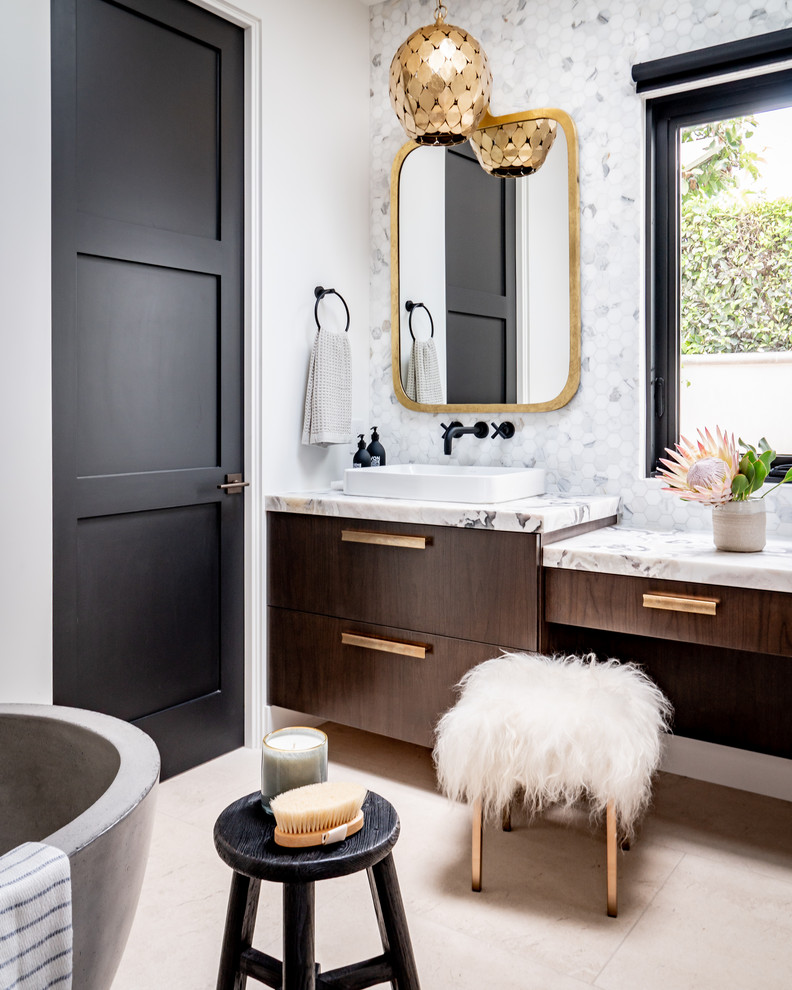 Mediterranean ensuite bathroom in Orange County with flat-panel cabinets, dark wood cabinets, multi-coloured tiles, white walls, a vessel sink, beige floors and multi-coloured worktops.