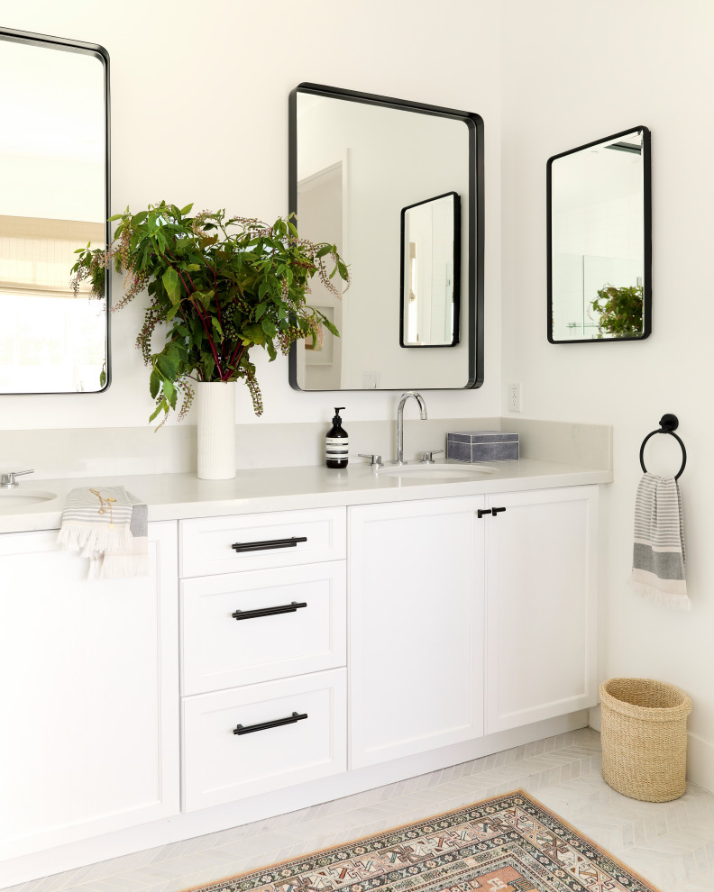 Imagen de cuarto de baño principal, doble y a medida actual de tamaño medio con puertas de armario blancas, bañera exenta, paredes blancas, suelo de mármol y suelo blanco