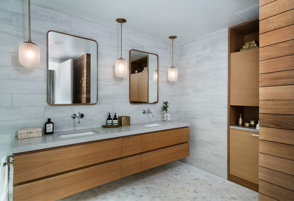 Стильный дизайн: главная ванная комната в современном стиле с плоскими фасадами, светлыми деревянными фасадами, серой плиткой, серыми стенами, врезной раковиной, серым полом, серой столешницей и зеркалом с подсветкой - последний тренд