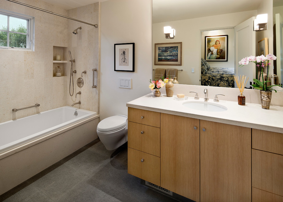 Immagine di una stanza da bagno mediterranea con vasca da incasso, vasca/doccia, WC sospeso e doccia con tenda
