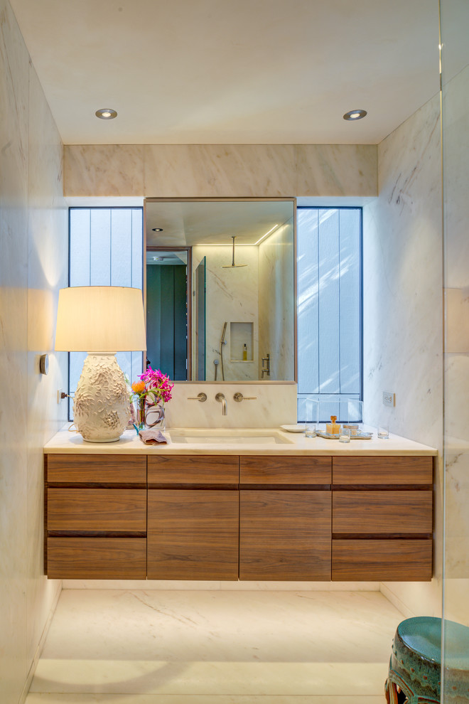 Foto di una stanza da bagno design con ante lisce, ante in legno scuro, piastrelle beige, pareti beige, lavabo sottopiano, pavimento beige e top beige