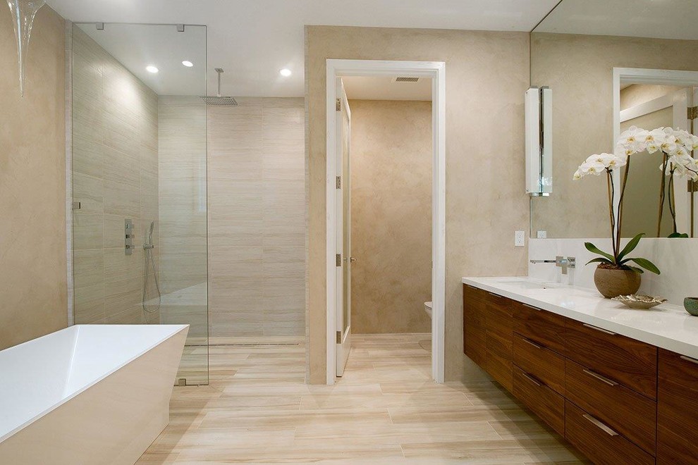 Exempel på ett mellanstort klassiskt en-suite badrum, med släta luckor, skåp i mellenmörkt trä, ett fristående badkar, en dusch i en alkov, en vägghängd toalettstol, beige kakel, porslinskakel, vita väggar, vinylgolv, ett undermonterad handfat, bänkskiva i akrylsten, brunt golv och med dusch som är öppen