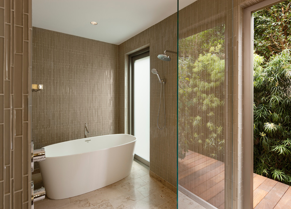 На фото: ванная комната в современном стиле с отдельно стоящей ванной, открытым душем, коричневой плиткой, стеклянной плиткой и открытым душем с