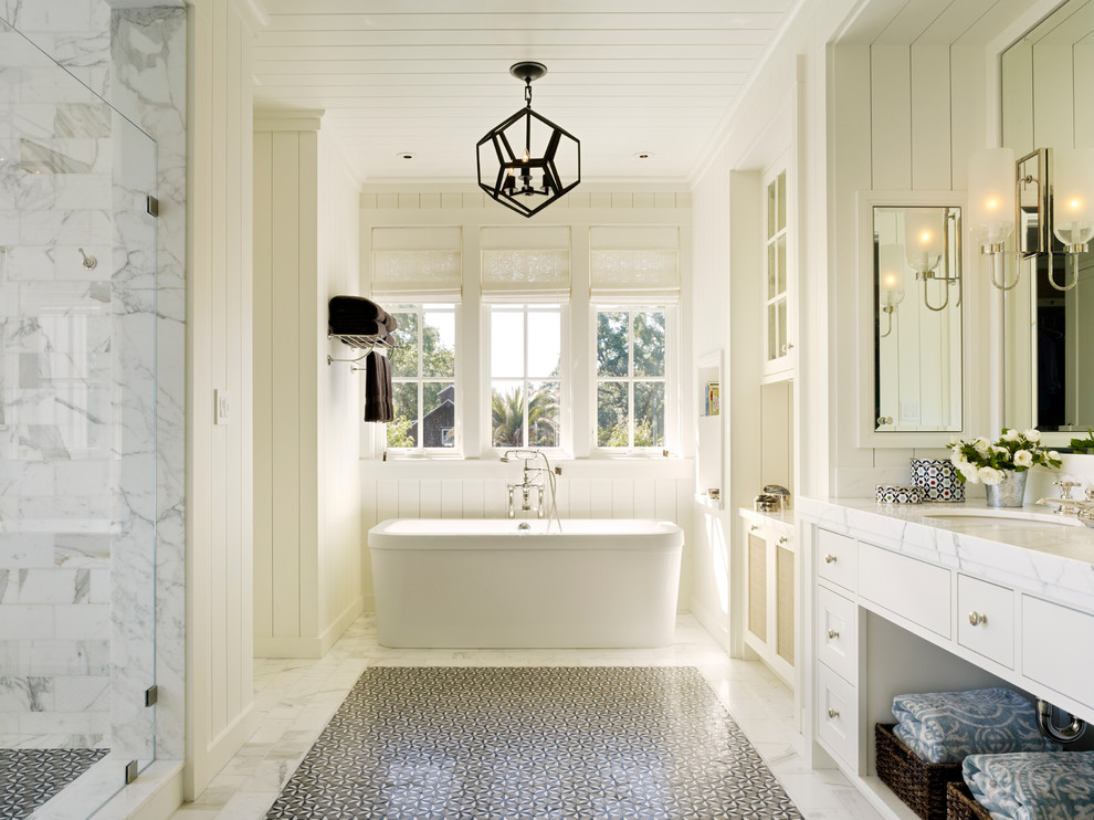 Photo of a farmhouse bathroom in San Francisco with a submerged sink, recessed-panel cabinets, white cabinets, a freestanding bath, an alcove shower, white tiles and white walls.