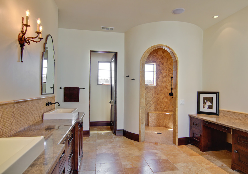Immagine di una stanza da bagno mediterranea con lavabo a bacinella, doccia a filo pavimento, ante in legno scuro, ante a filo e piastrelle beige
