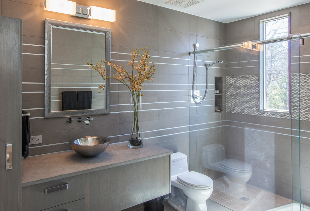 Modernes Badezimmer mit flächenbündigen Schrankfronten, dunklen Holzschränken, Duschnische, grauen Fliesen, Aufsatzwaschbecken, grauem Boden, Schiebetür-Duschabtrennung, grauer Waschtischplatte und Einzelwaschbecken in Dallas