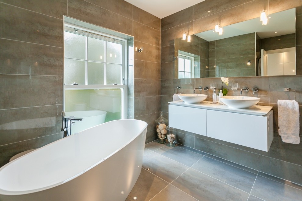 Immagine di una grande stanza da bagno padronale design con vasca freestanding, doccia aperta, piastrelle grigie e piastrelle in gres porcellanato