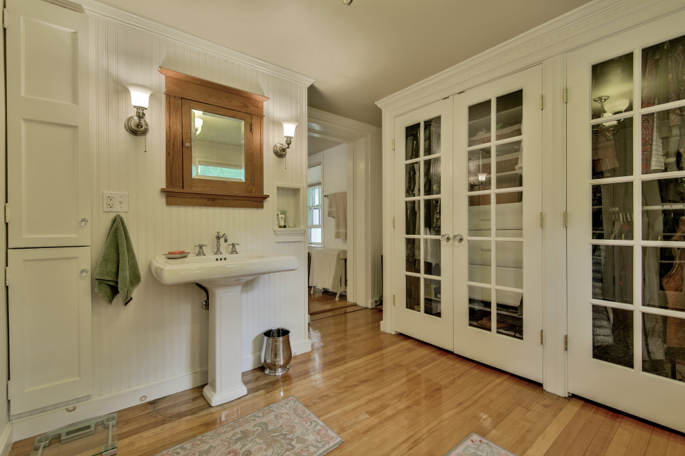 Esempio di una grande stanza da bagno padronale classica con pareti bianche, parquet chiaro, lavabo a colonna, toilette, un lavabo, soffitto a cassettoni e pareti in legno