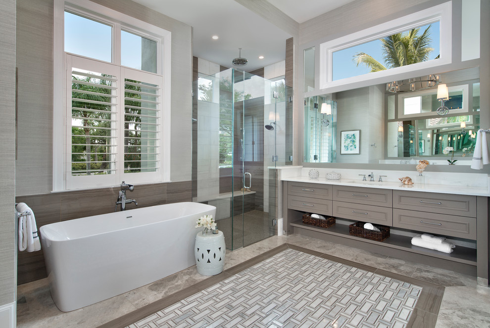 Großes Klassisches Badezimmer En Suite mit grauem Boden, verzierten Schränken, braunen Schränken, freistehender Badewanne, Eckdusche, grauer Wandfarbe, Betonboden, Unterbauwaschbecken, Quarzwerkstein-Waschtisch und Falttür-Duschabtrennung in Miami