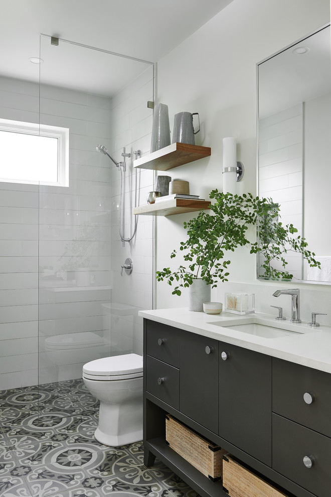 Modern inredning av ett mellanstort vit vitt badrum med dusch, med grå skåp, en öppen dusch, en toalettstol med hel cisternkåpa, vita väggar, cementgolv, ett fristående handfat, bänkskiva i kvartsit, grått golv, med dusch som är öppen och släta luckor