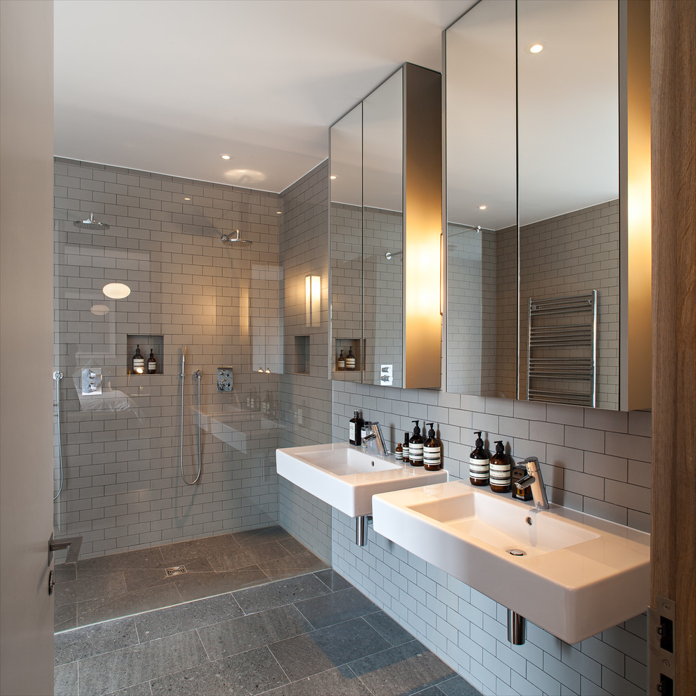 Ejemplo de cuarto de baño actual de tamaño medio con lavabo suspendido, ducha esquinera, baldosas y/o azulejos grises, baldosas y/o azulejos de cemento y paredes grises
