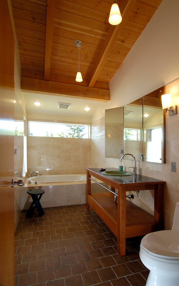 Réalisation d'une salle de bain design avec un lavabo posé et un sol marron.
