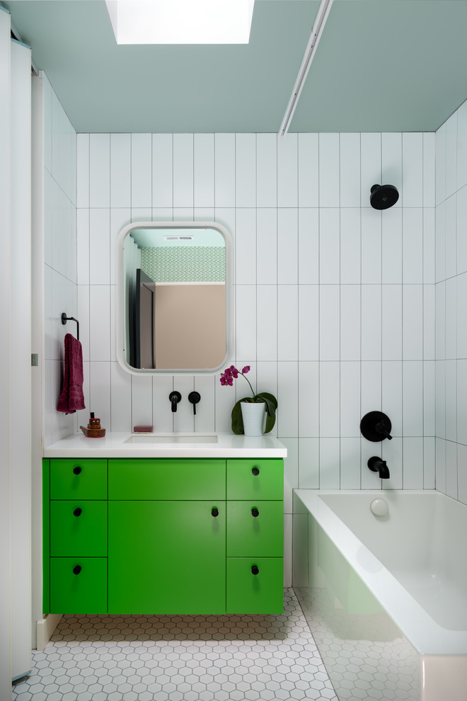 Cette image montre une salle de bain design avec un placard à porte plane, des portes de placards vertess, une baignoire d'angle, un combiné douche/baignoire, un carrelage blanc, un lavabo encastré, un sol blanc, une cabine de douche avec un rideau et un plan de toilette blanc.