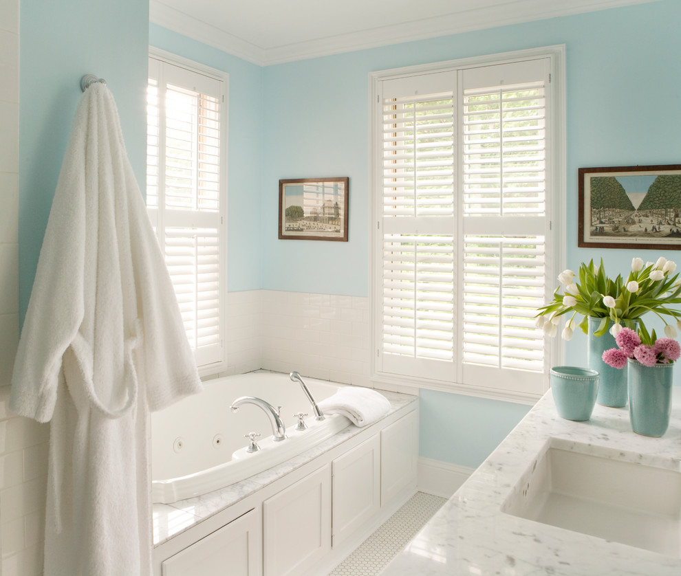Bild på ett litet vintage en-suite badrum, med ett platsbyggt badkar, blå väggar, mosaikgolv, luckor med infälld panel, vita skåp, marmorbänkskiva, vit kakel, keramikplattor och en dusch i en alkov