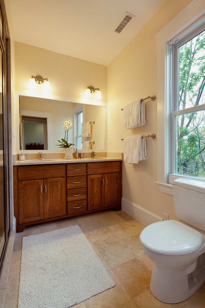 Idee per una stanza da bagno chic di medie dimensioni con ante in legno scuro, pareti gialle, lavabo sottopiano e top in granito