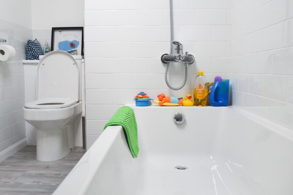 Esempio di una stanza da bagno padronale minimal di medie dimensioni con vasca da incasso, WC sospeso, piastrelle gialle, pareti bianche, pavimento in vinile e lavabo a colonna