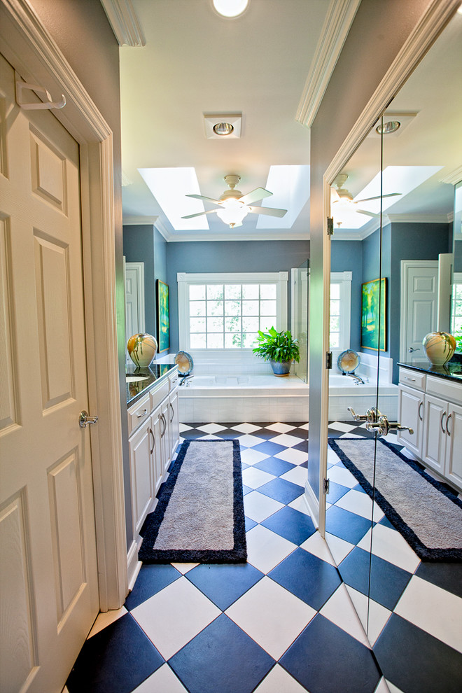 Example of a mid-sized classic master black tile and ceramic tile ceramic tile bathroom design in Other with an undermount sink, glass-front cabinets, white cabinets, granite countertops, a one-piece toilet and blue walls