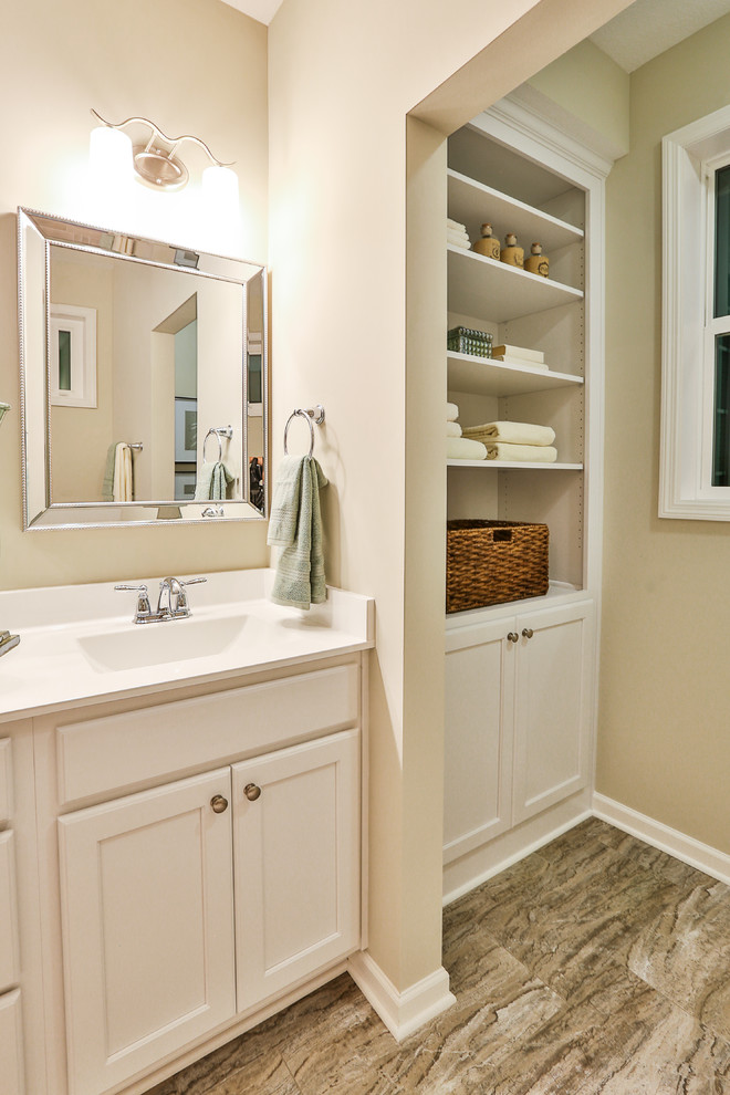 Cette photo montre une salle de bain principale tendance en bois brun de taille moyenne avec un placard avec porte à panneau surélevé, une baignoire posée, WC à poser, un carrelage multicolore et un sol en vinyl.