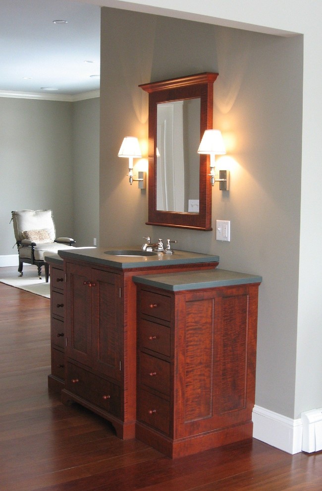 Example of a small classic master dark wood floor bathroom design in Portland Maine with flat-panel cabinets, dark wood cabinets, gray walls, an undermount sink and solid surface countertops