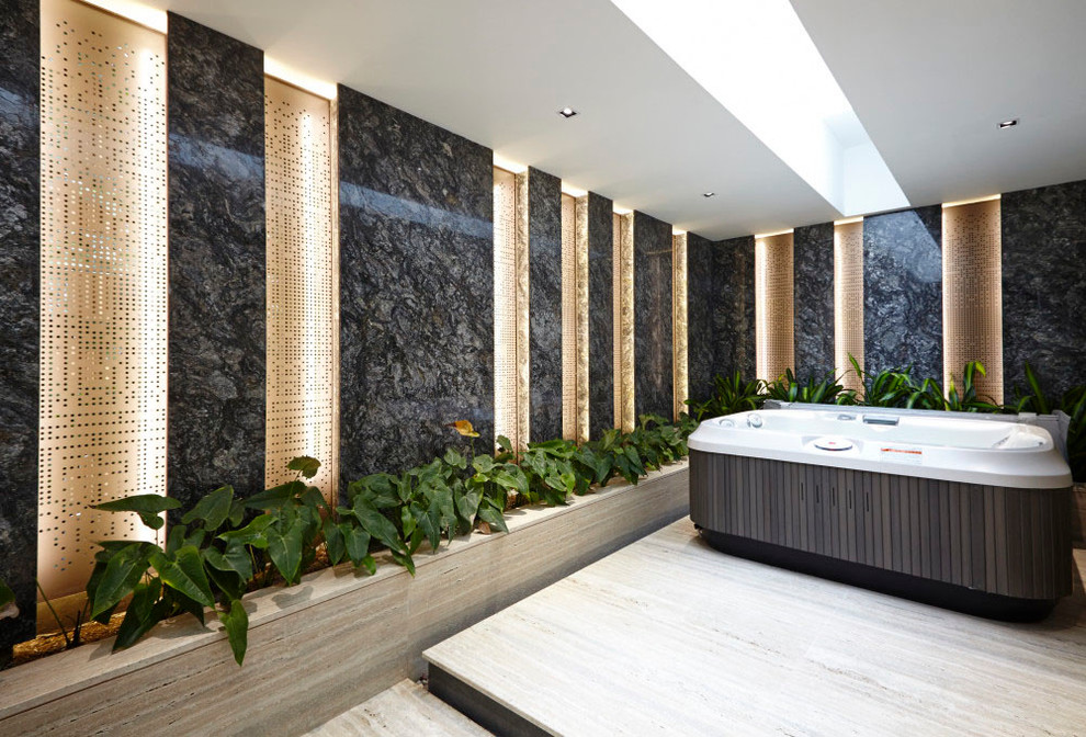 Idée de décoration pour une salle de bain design avec un sol en travertin, un bain bouillonnant et un mur multicolore.