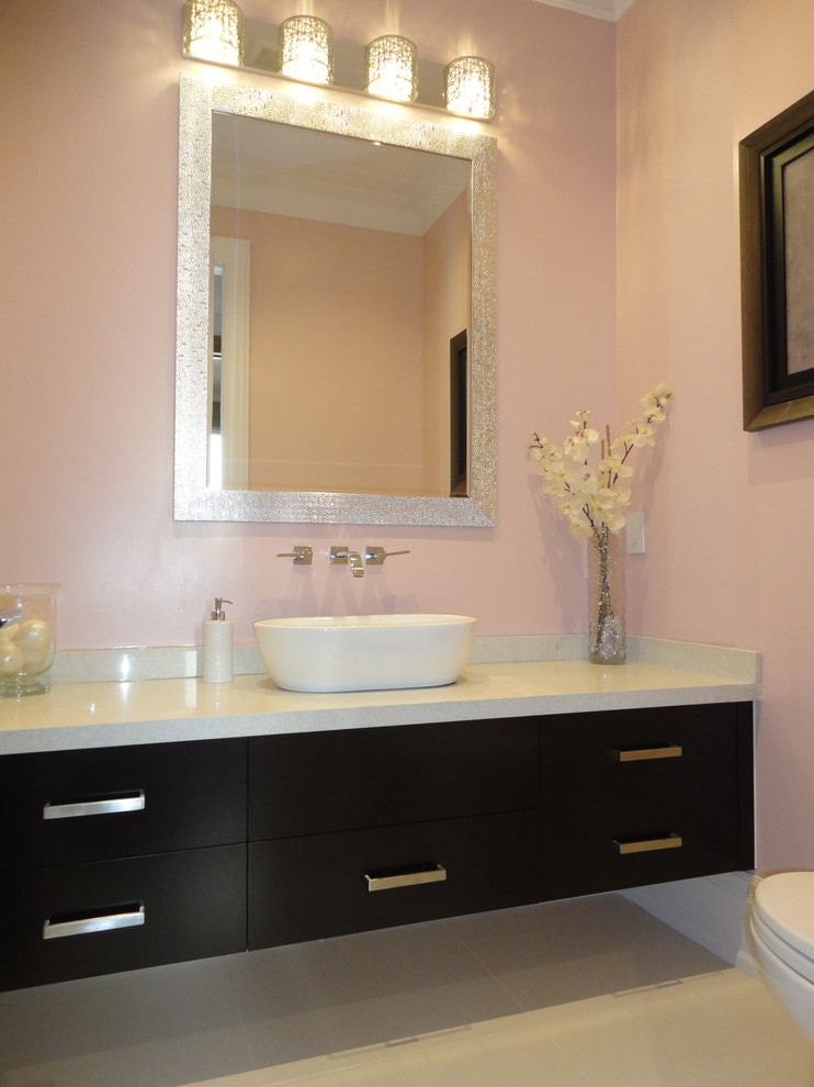 Réalisation d'une salle de bain design en bois foncé de taille moyenne avec un lavabo de ferme, un placard à porte plane, WC à poser, un mur rose et un sol en carrelage de céramique.