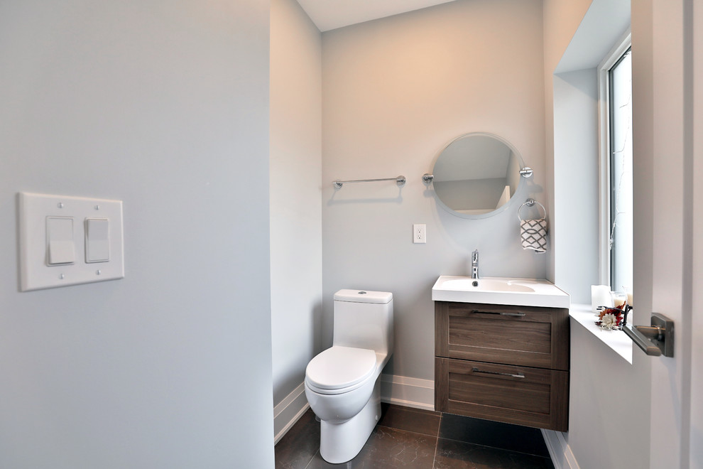 Réalisation d'une salle de bain principale minimaliste en bois brun de taille moyenne avec un placard à porte affleurante, WC à poser, un mur gris et un plan vasque.