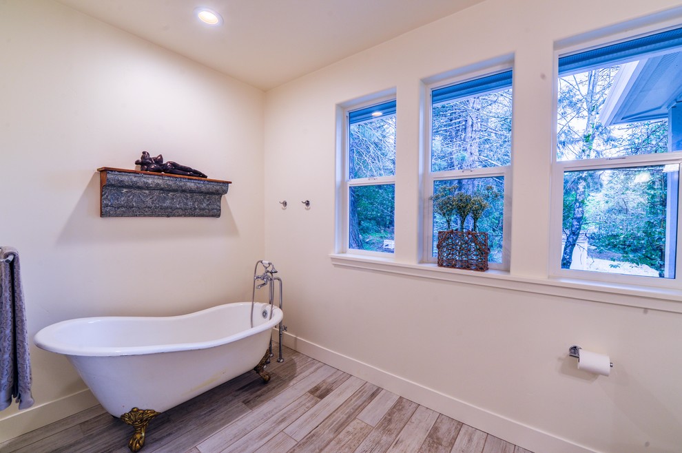 Ispirazione per una stanza da bagno padronale tradizionale di medie dimensioni con vasca con piedi a zampa di leone, pareti bianche e pavimento beige