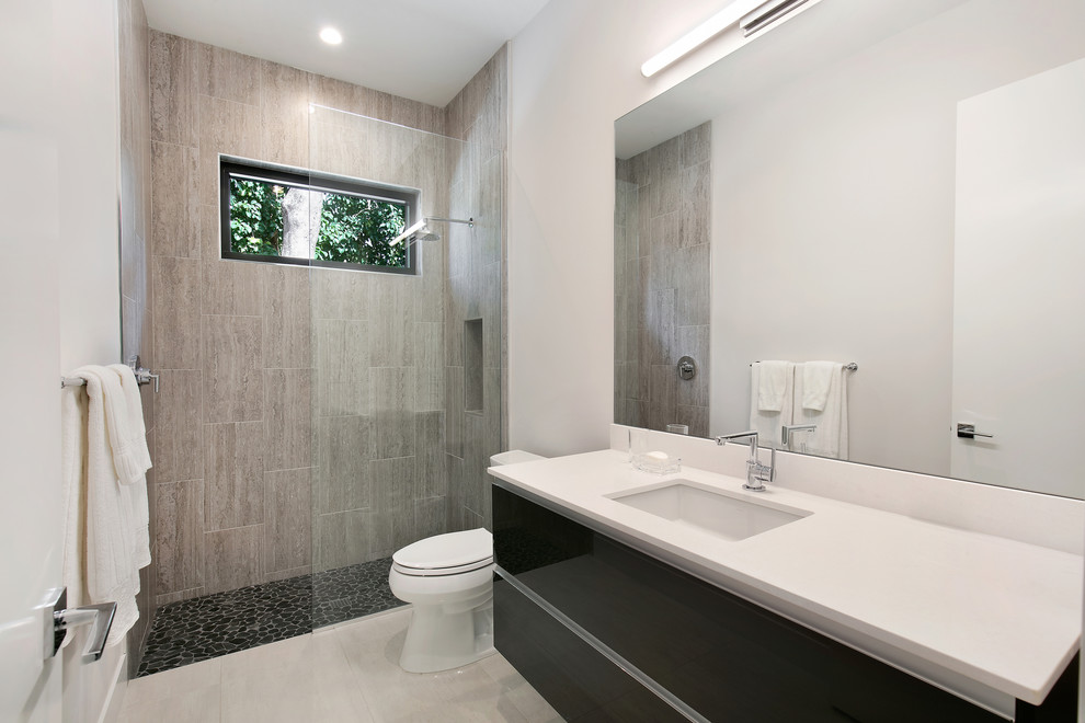 Bathroom - mid-sized modern kids' gray tile and porcelain tile porcelain tile and white floor bathroom idea in Tampa with flat-panel cabinets, gray cabinets, a two-piece toilet, white walls, an undermount sink, quartz countertops and white countertops