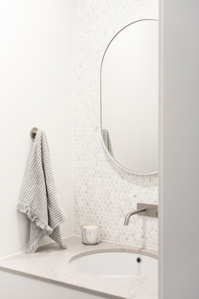 Пример оригинального дизайна: маленькая ванная комната в современном стиле с плоскими фасадами, светлыми деревянными фасадами, двойным душем, унитазом-моноблоком, серой плиткой, мраморной плиткой, белыми стенами, полом из керамогранита, душевой кабиной, врезной раковиной, столешницей из искусственного кварца, серым полом, душем с распашными дверями и серой столешницей для на участке и в саду